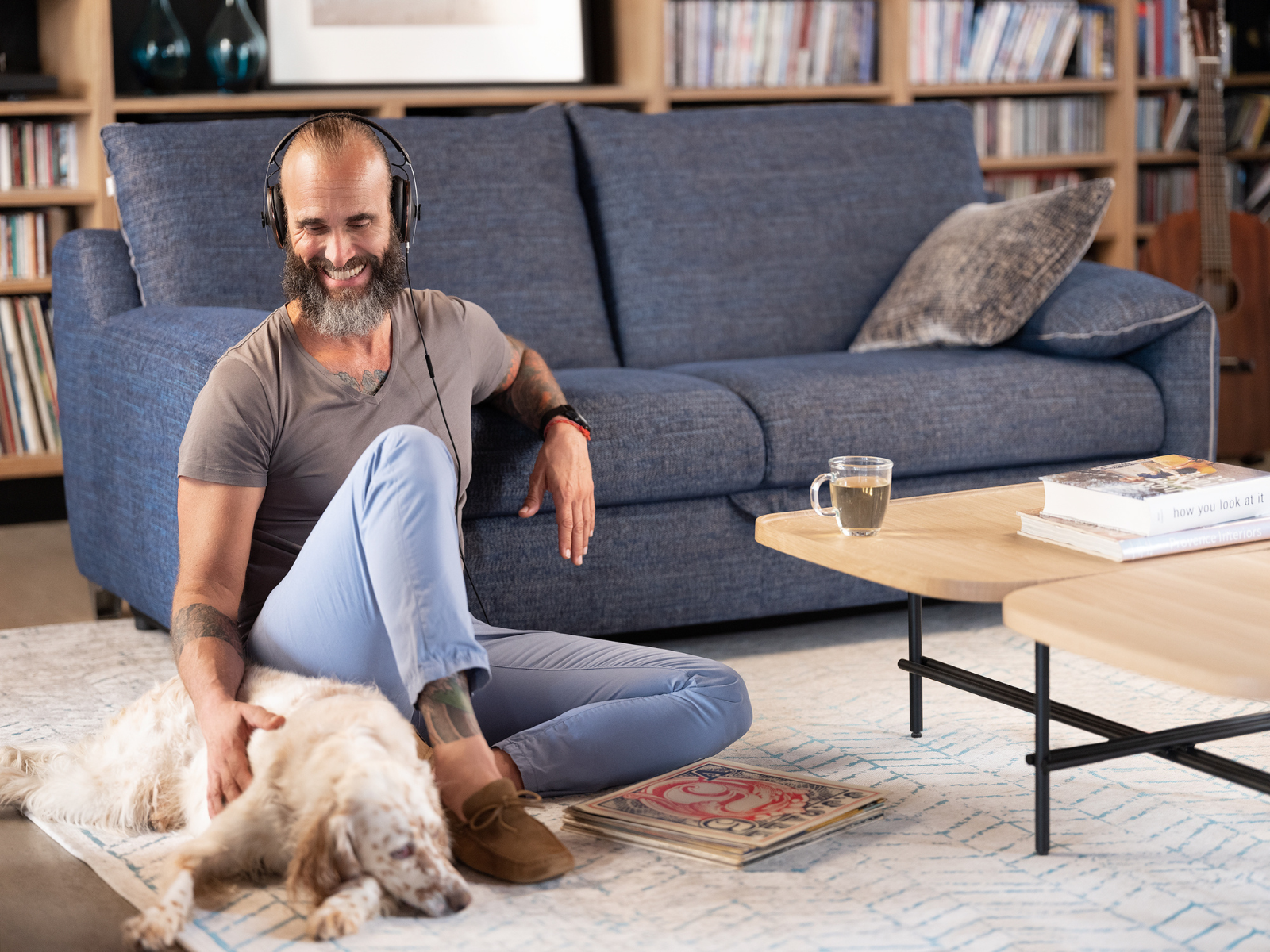 NOKTO_11 Mann mit Hund neben einem blauen Schlafsofa